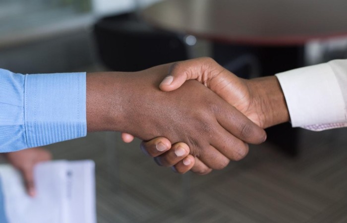 Customer shakes hands with businessman to represent sale from the bottom of the funnel